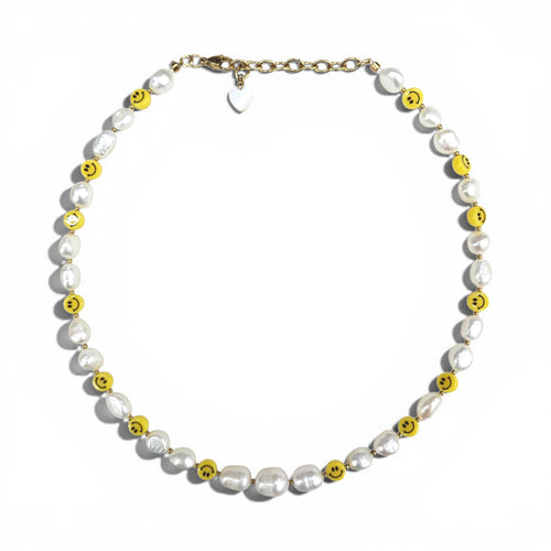 HANAÉ Smile Pearl Necklace featuring white freshwater pearls and yellow smiley face beads with gold-tone accents on a white background.