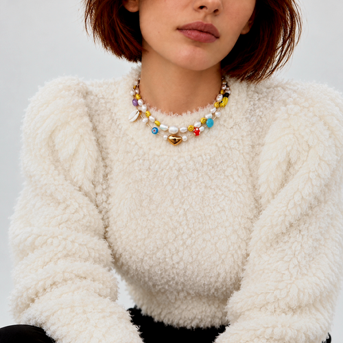 HANAÉ Curated Playful Mix Gemstone Necklace featuring colorful mixed beads, freshwater pearls and shell accents, styled with an ivory textured winter sweater.